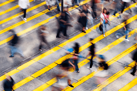 A blurred photo of a busy pedestrian crossing in a city. 